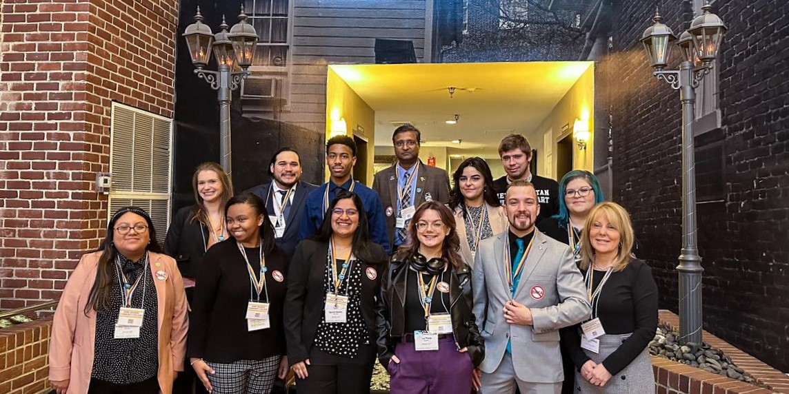 A group of students and Dr. Dawn Lindsay stand on steps and smile during Student Advocacy Day.