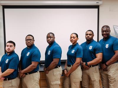 Police academy students posing together in their uniforms.