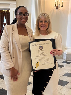 Dr. Lindsay and Senator Henson's Chief of Staff holding a citation.