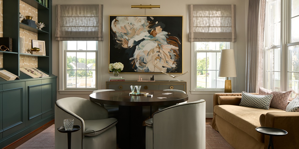 Interior of a designed entertainment room with a central table and bookshelves.