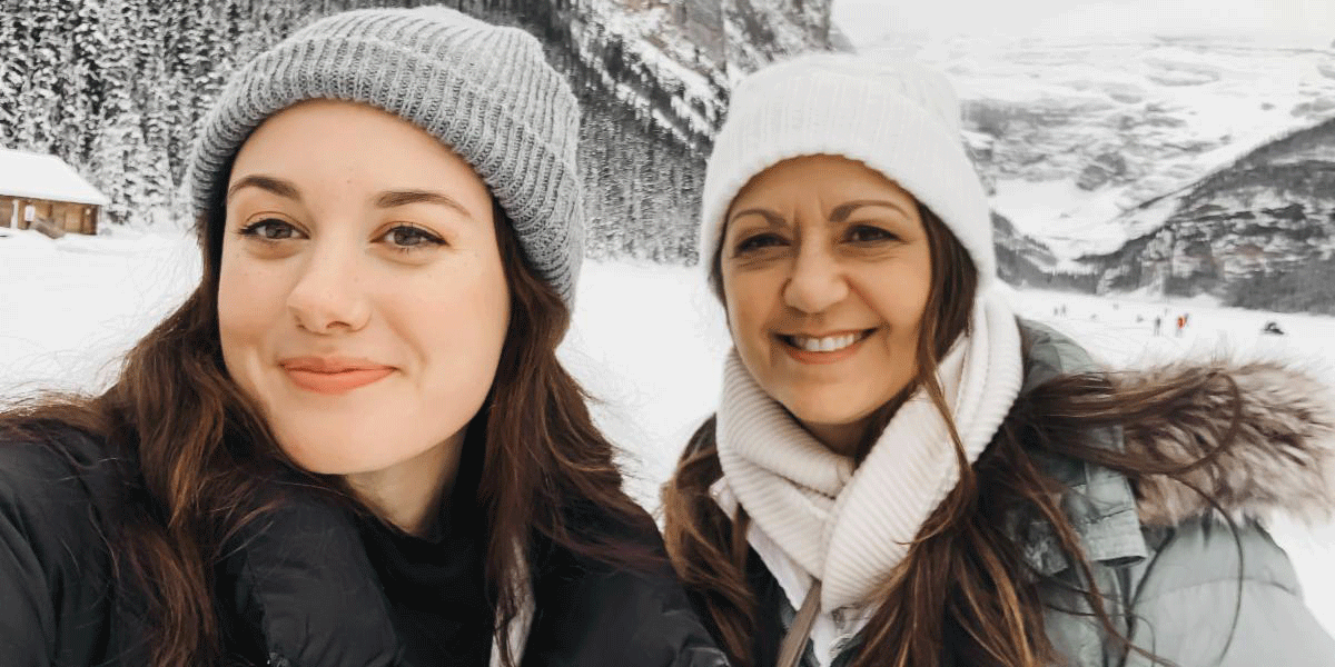 Tia and Theresa Bustanoby in hats and coats with snow and mountains in the background