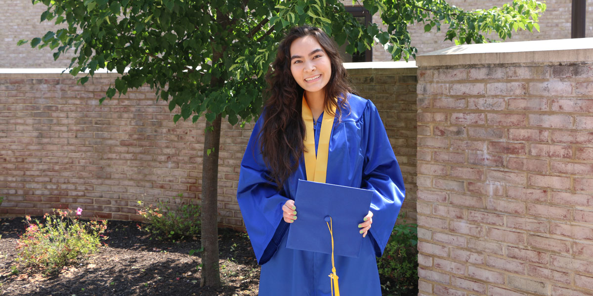 Image of Esther Kuhnert in graduation cap and gown.