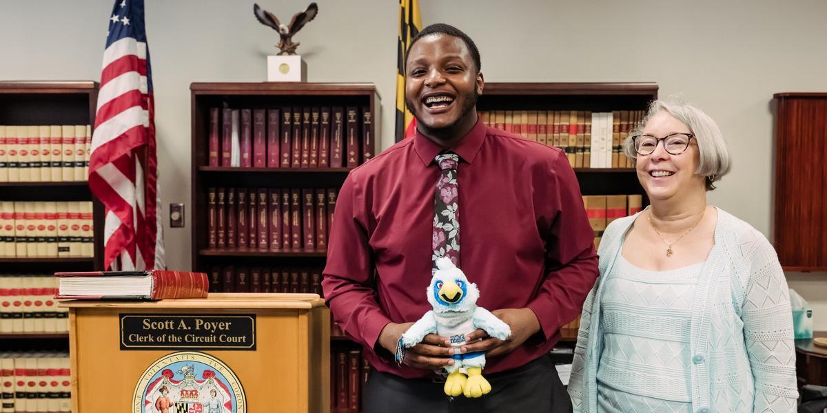 Keshawn Johnson holds a stuffed Swoop mascot after being sworn in as student member of board.