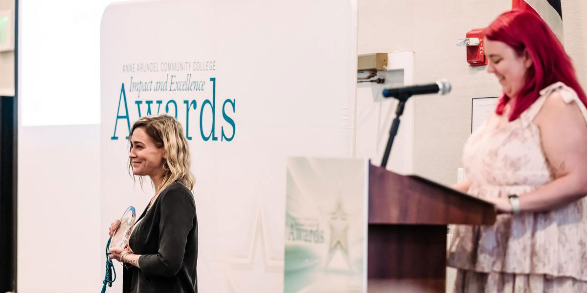 Meredith Dales accepting an award at Impact and Excellence