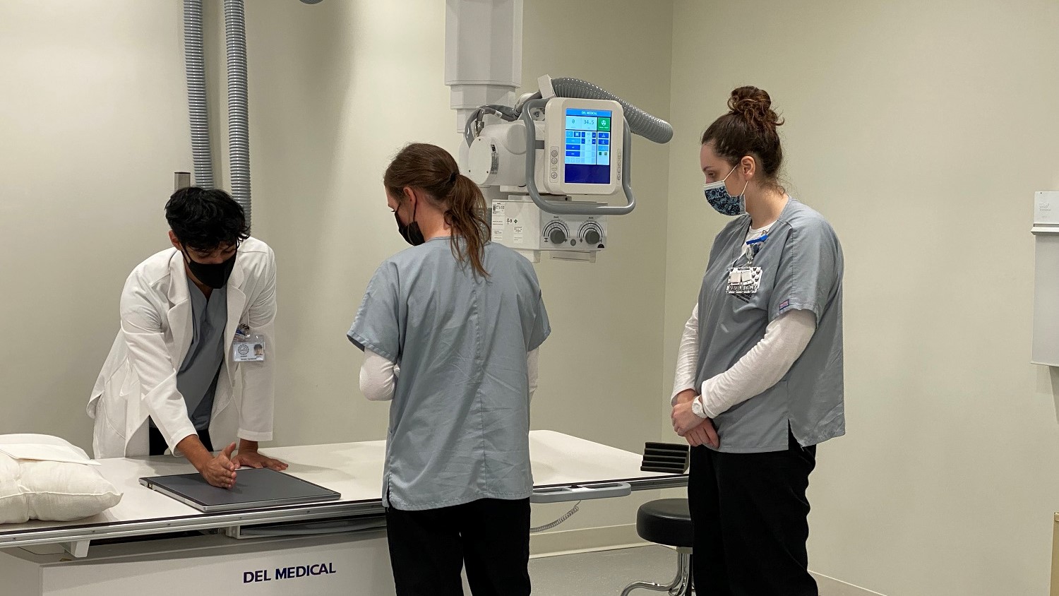 Three radiologic technology students in the X-ray lab at AACC.