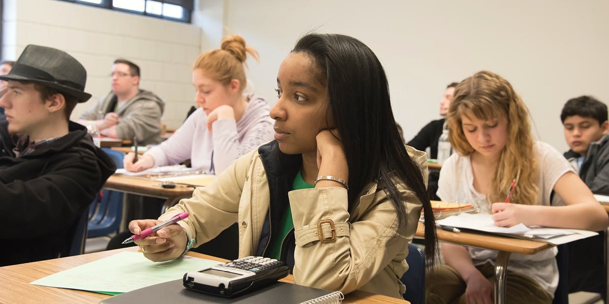 Female student sitting at a classroom desk.