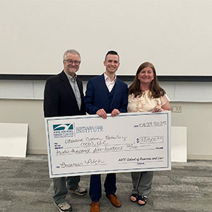 Kenneth Thomas holding a large check.