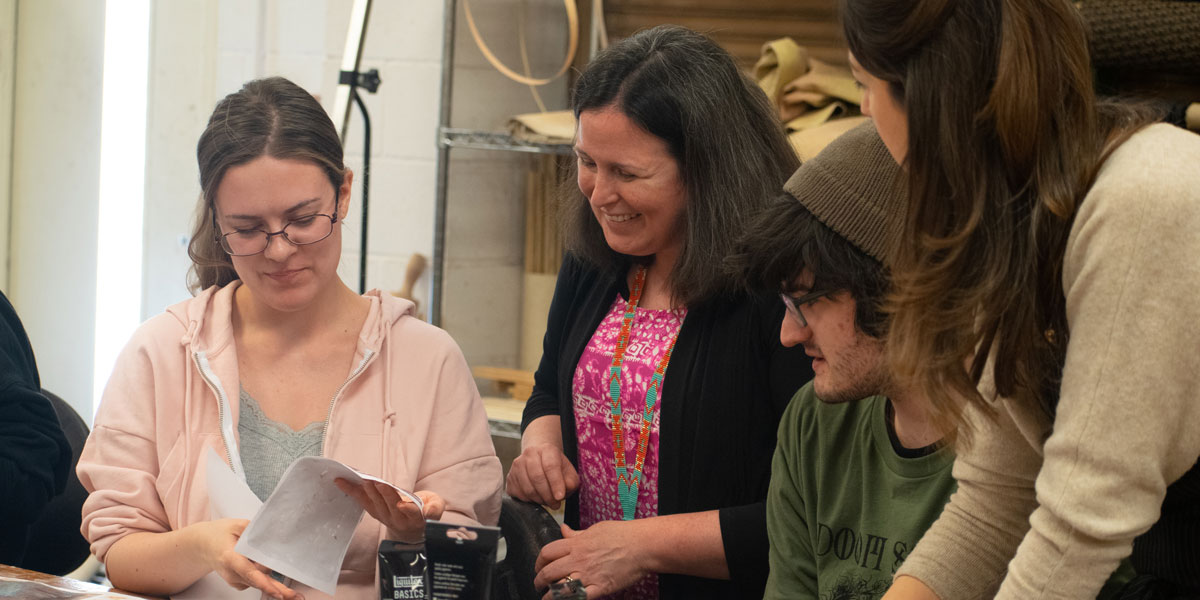 Instructors reviewing student's art project.