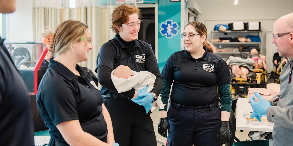 EMT students with mannekin baby.