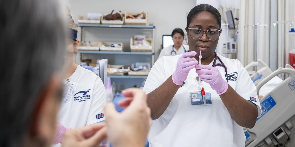 Nursing student working with a needle.