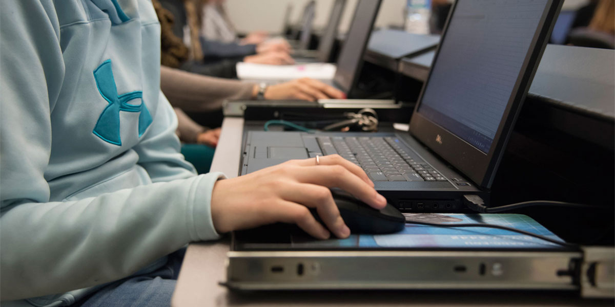 Student using laptop in computer lab