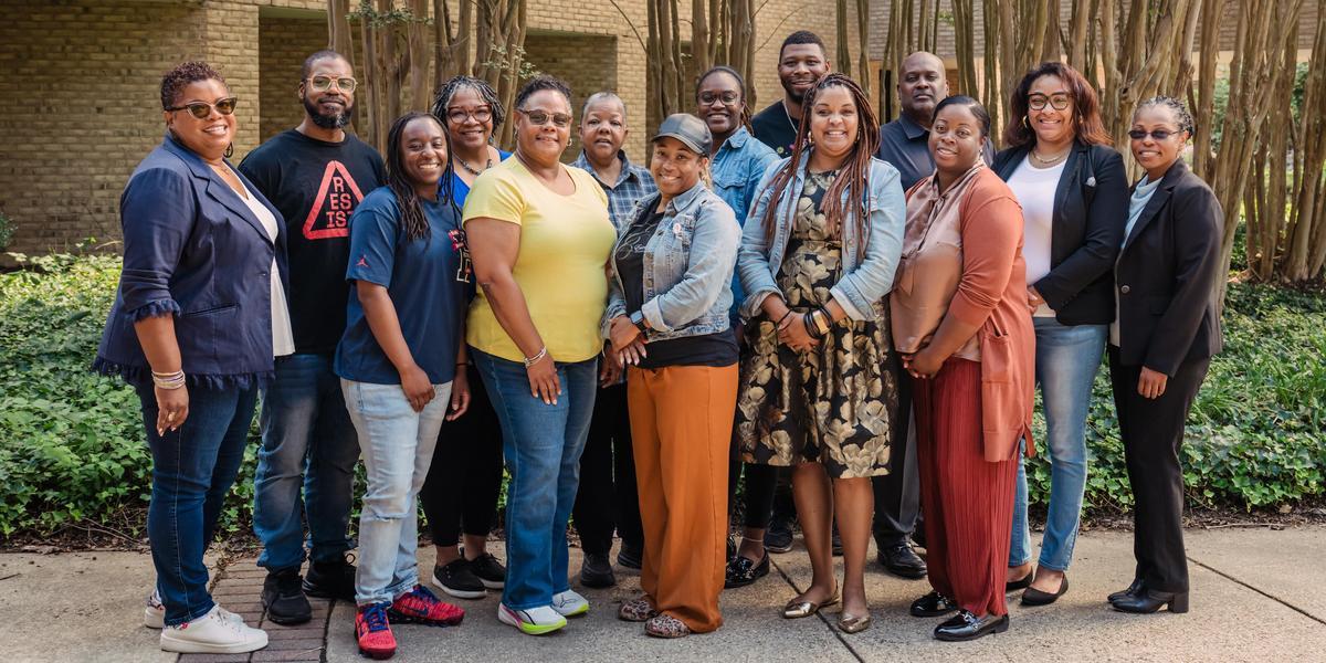 Group of AACC employees posed in exterior of AACC campus.