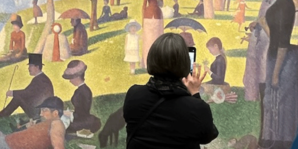 Karen Barber taking a photo of a painting.