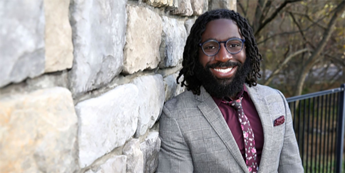 Lavon Davis leaning against a stone wall