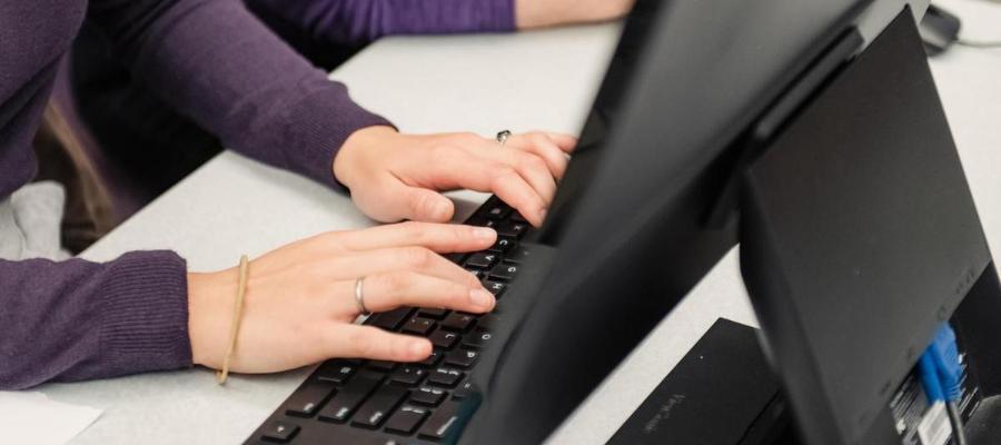 Student typing on a keyboard