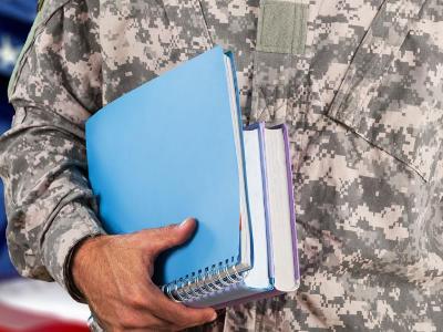 Military man in uniform with books.